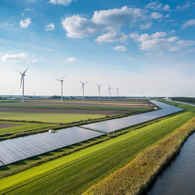 Solar panels and wind turbines in a field
