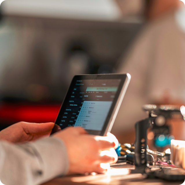 A close up of a person's hands working on a tablet.