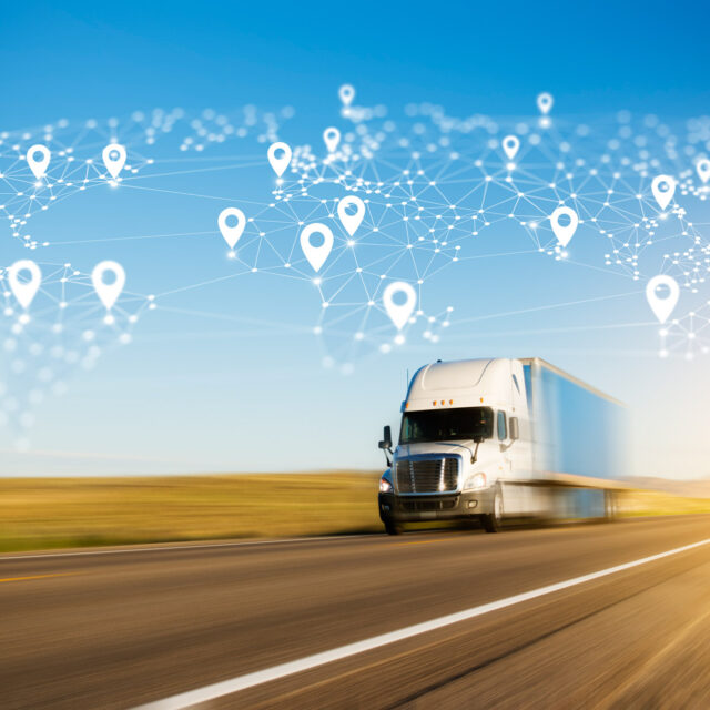 A truck drives on a highway with a digital world map overlay showing connected location markers.