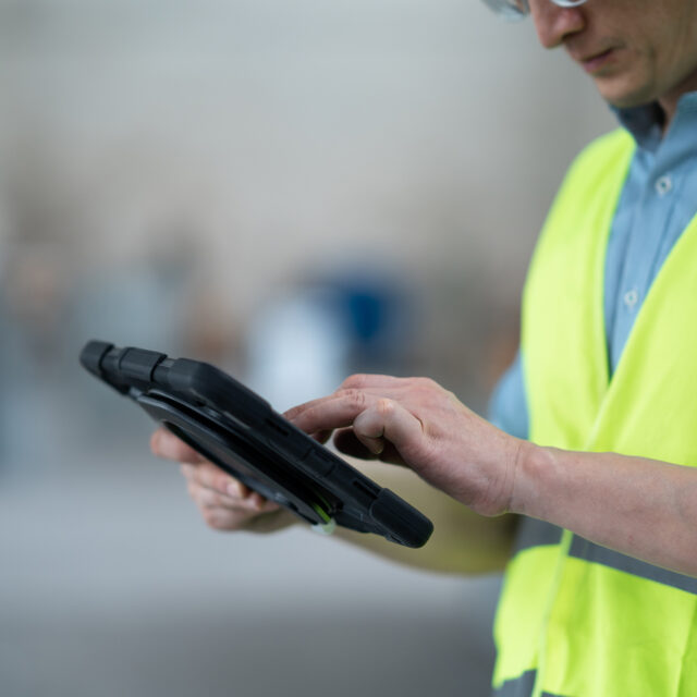 person working with tablet in workshop