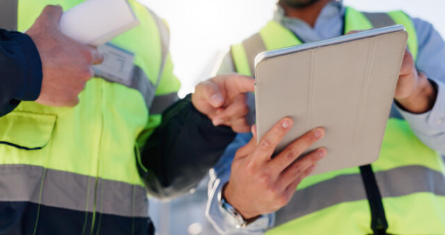 Engineers holding a tablet and talking
