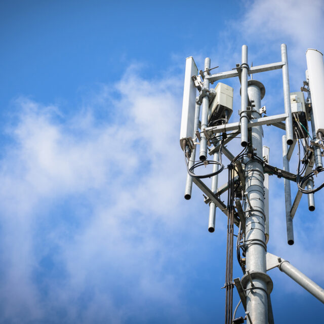 Telecommunications Tower with antennas on blue sky with cloud