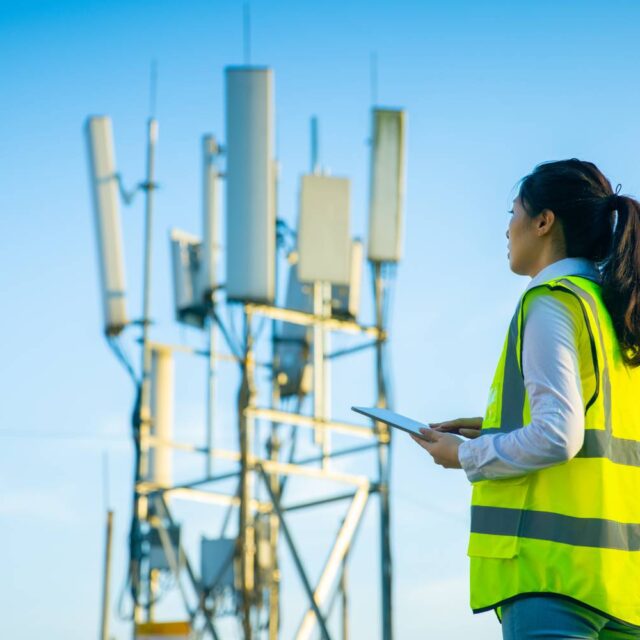 Woman standing in front of a cell tower