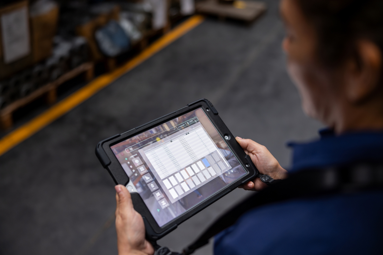 Close-up on a warehouse worker using a digital tablet while searching for merchandise